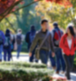 A blurry image of students walking on campus.